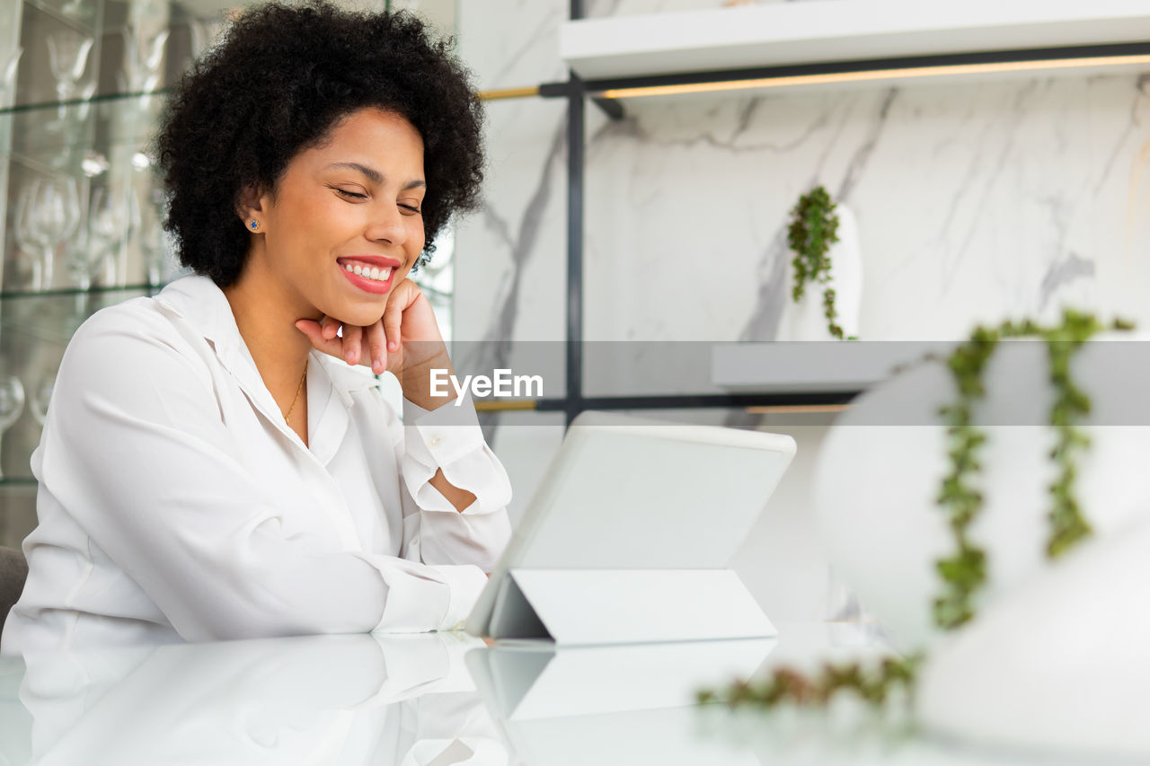 Young woman looking down while sitting on table