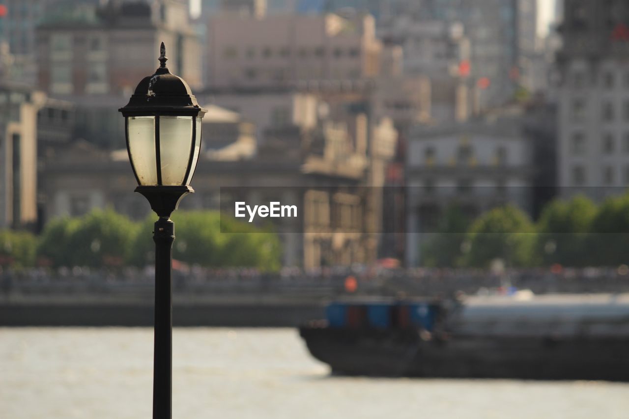 Close-up of street light against cityscape