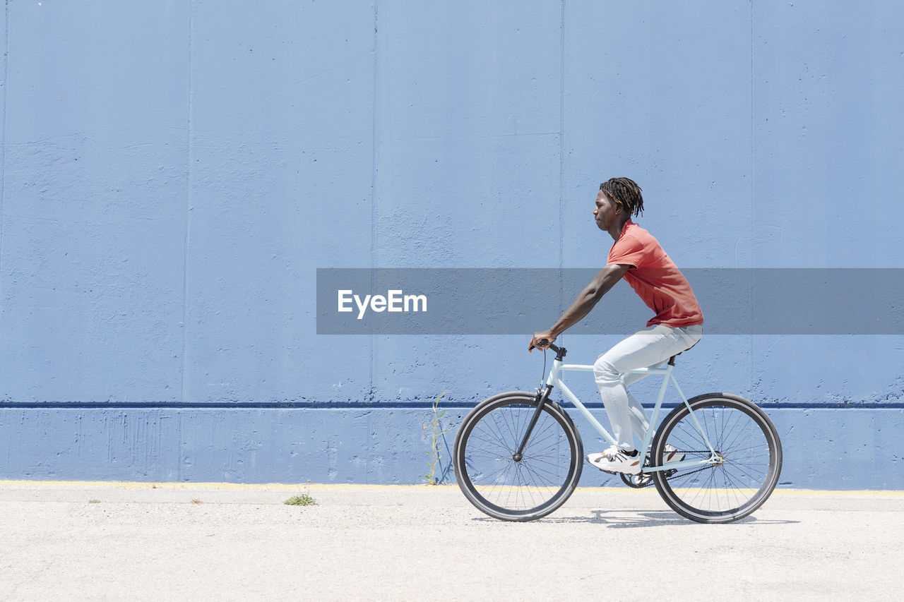 Man riding bicycle on embankment