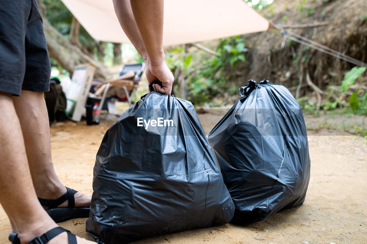 REAR VIEW OF MAN HOLDING PLASTIC BAG