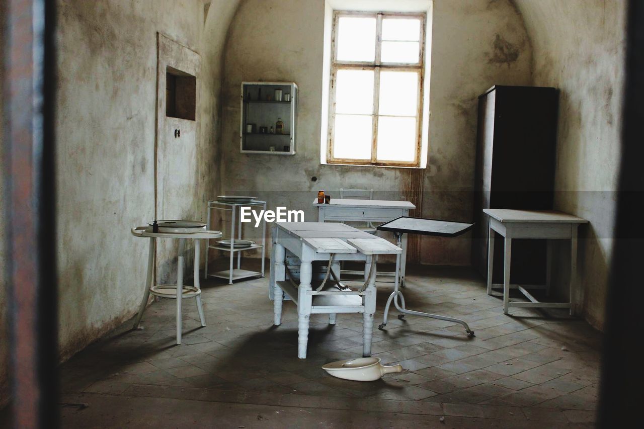 Empty chairs and table in abandoned room
