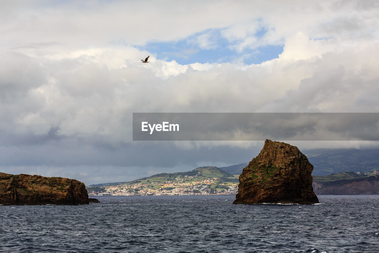 Scenic view of rock formation in sea against sky