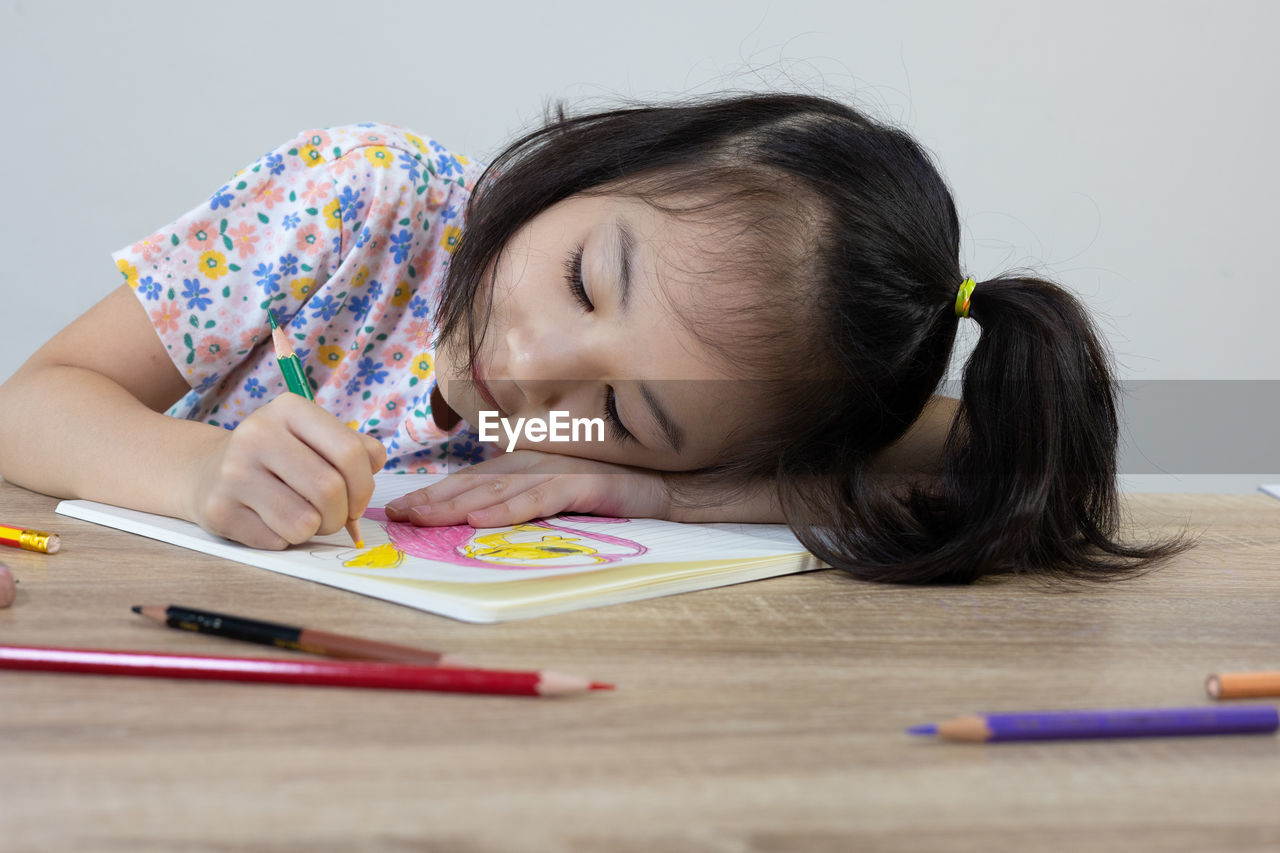 close-up of boy drawing on book at home