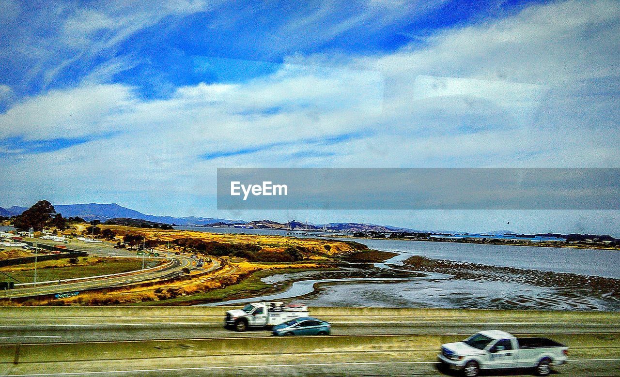 VIEW OF CAR ON ROAD AGAINST SKY