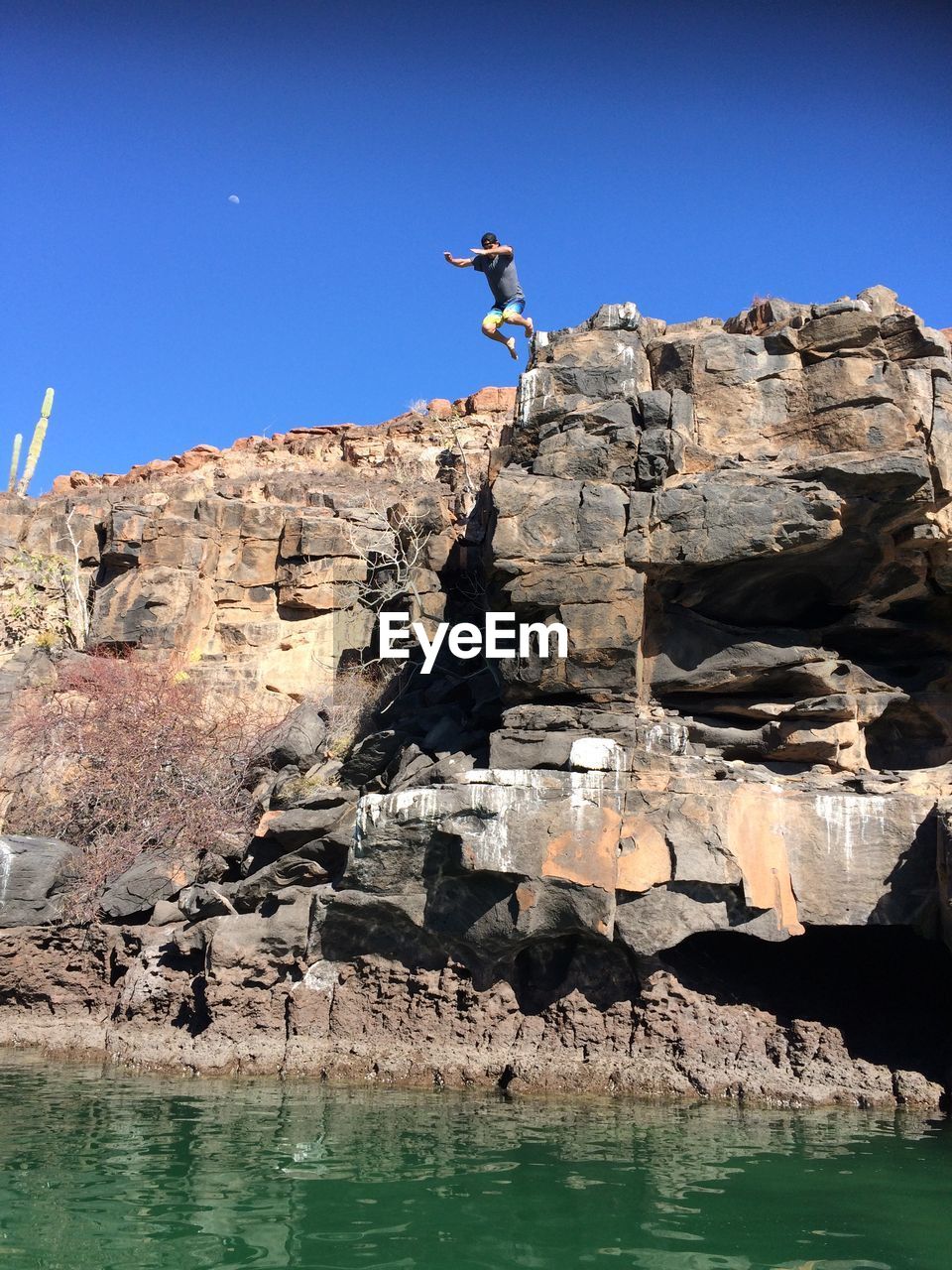 ROCKS IN WATER AGAINST ROCK FORMATION