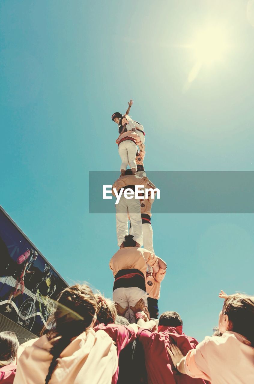 Low angle view of castellers forming human pyramid against clear sky