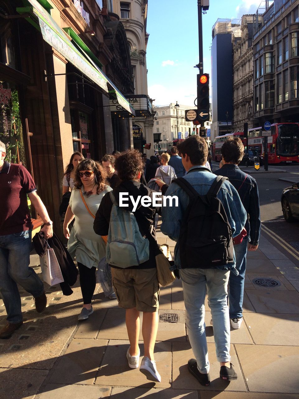 GROUP OF PEOPLE WALKING ON STREET IN CITY