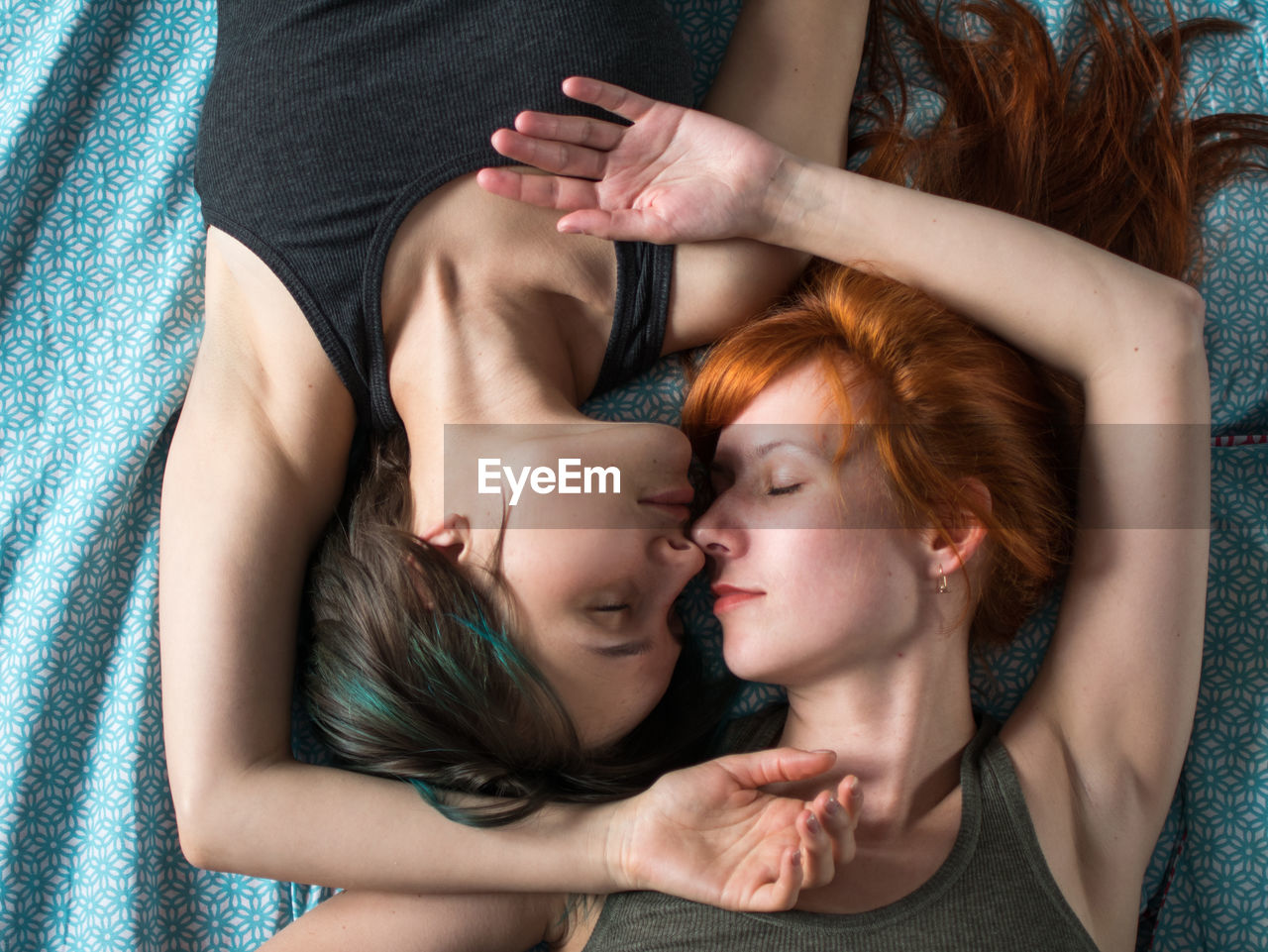 High angle view of lesbian couple lying on bed