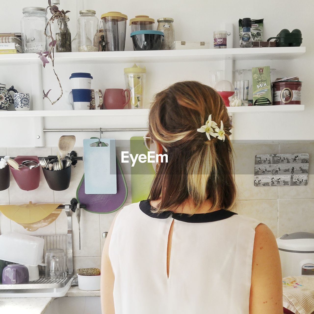 REAR VIEW OF WOMAN STANDING IN FRONT OF KITCHEN