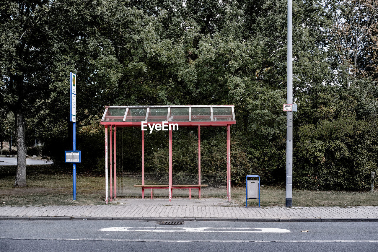 Empty bus stop against trees