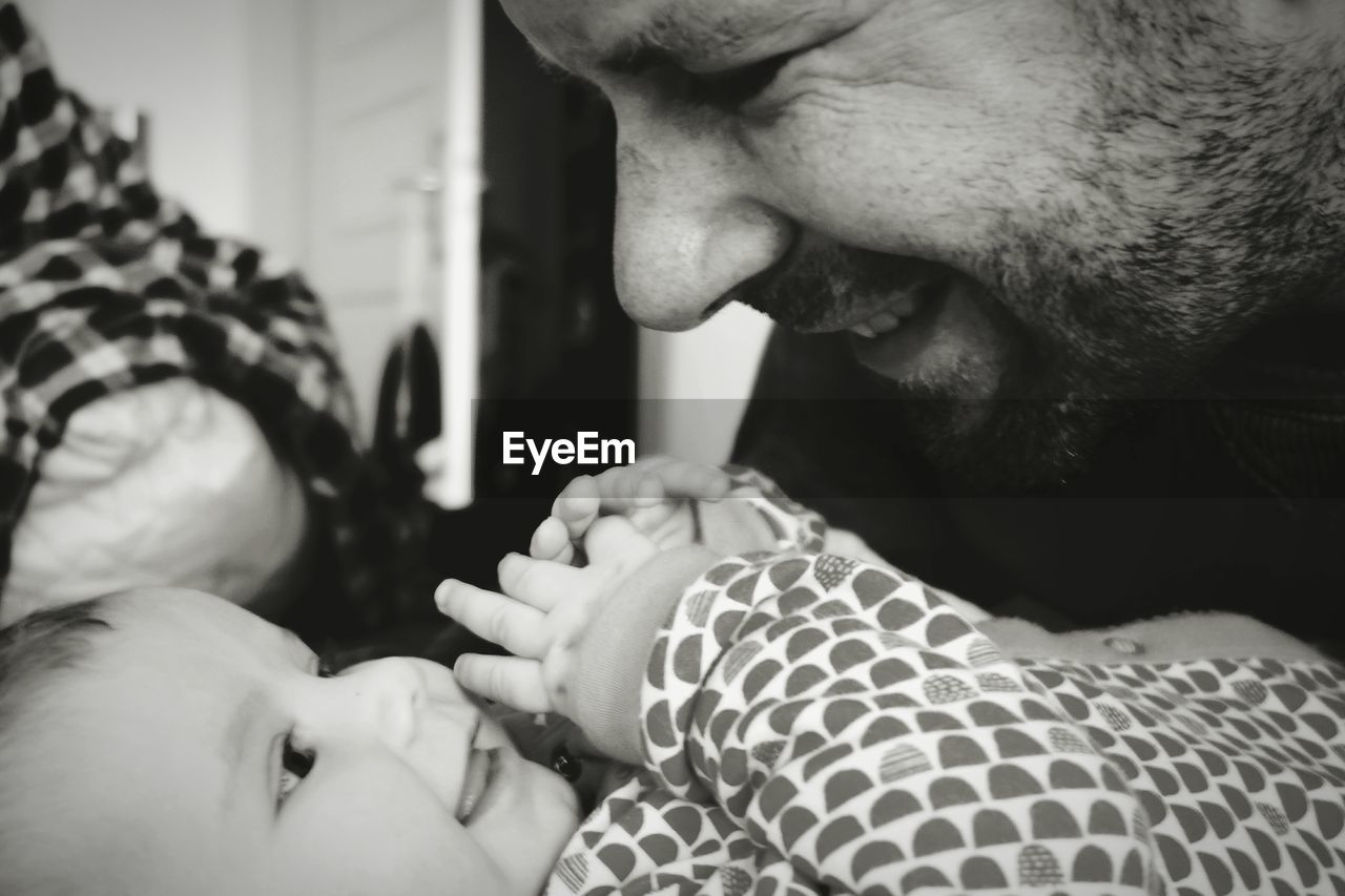 Close-up of baby girl and father at home