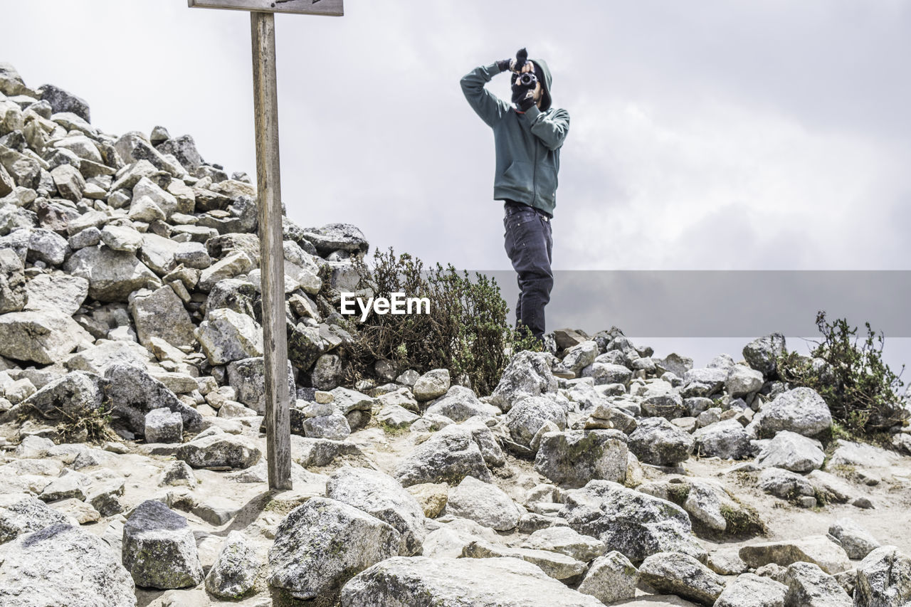 Man photographing on rock