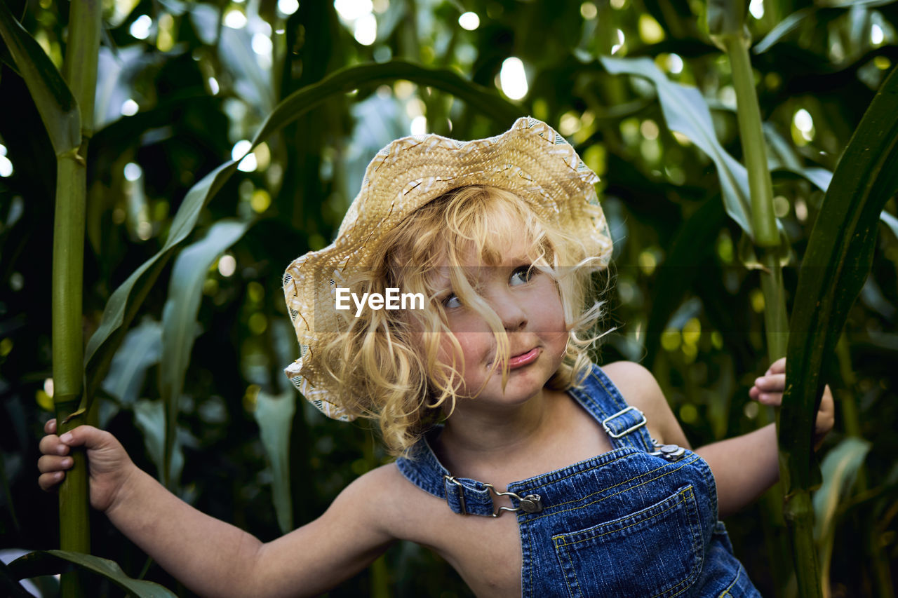 Portrait of cute girl with plants in background