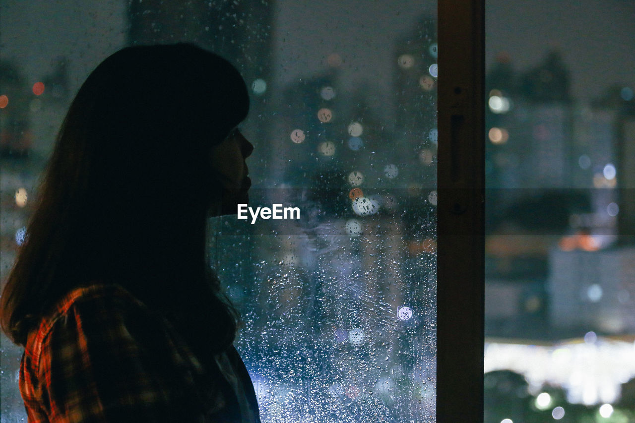 Woman looking at view through window