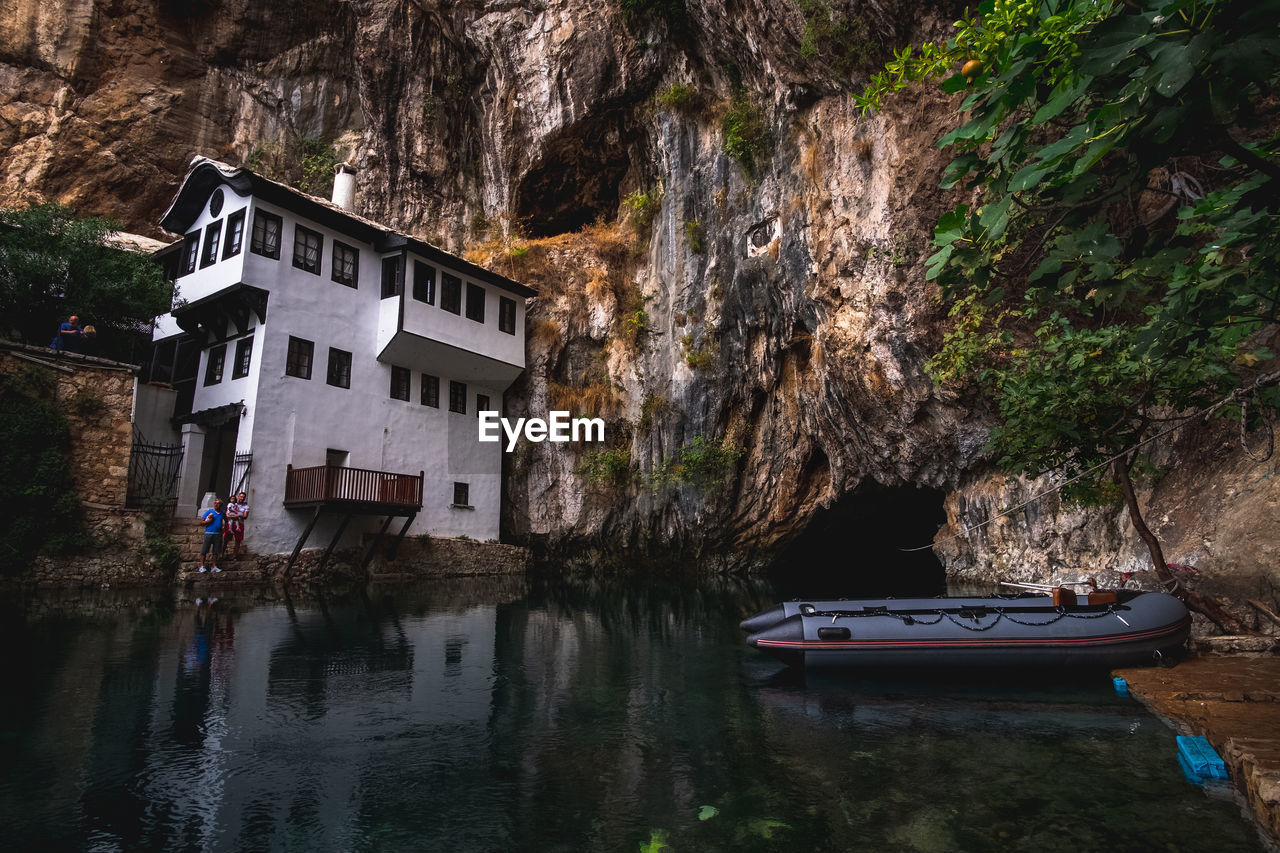 Scenic view of lake by buildings against mountain