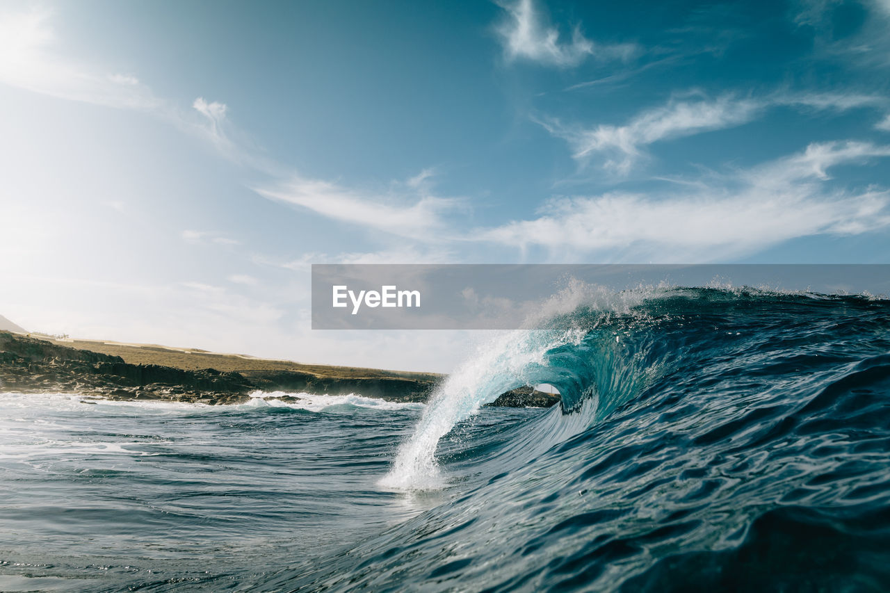 Scenic view of waves in sea against sky