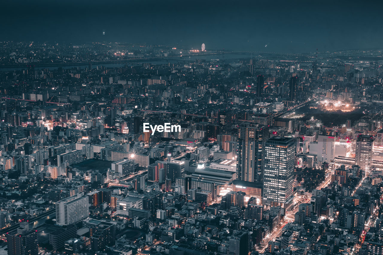 Aerial view of illuminated city against sky at night