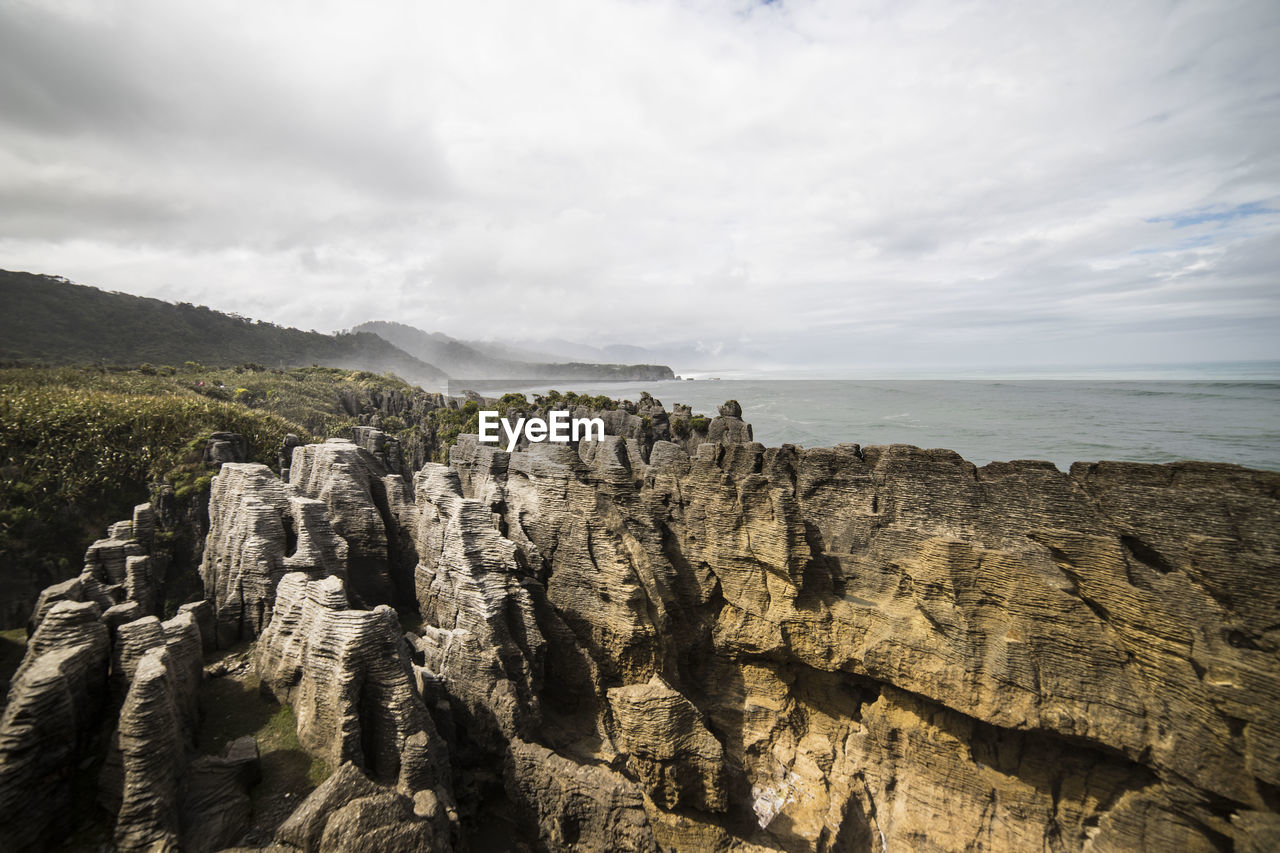 Scenic view of sea and mountains against sky