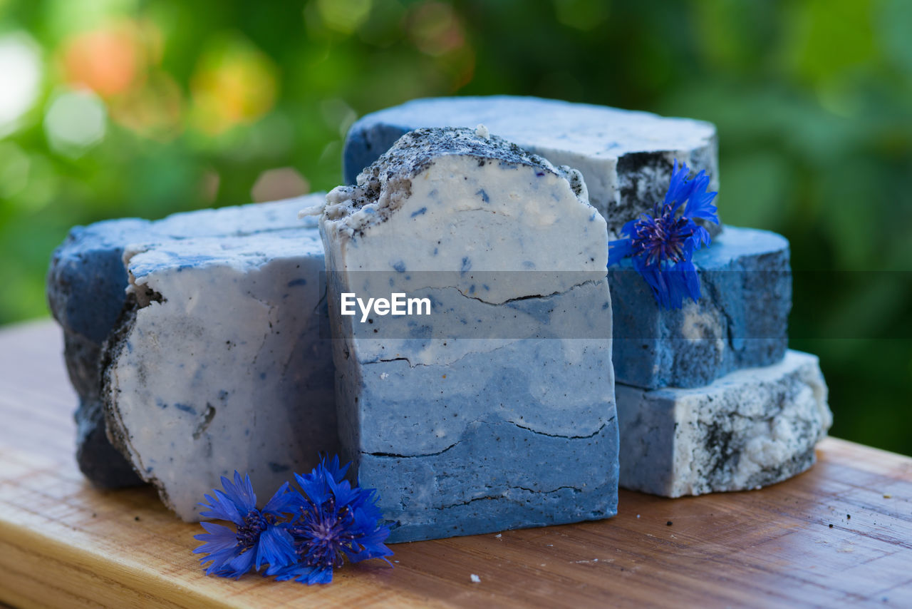 Dark blue handmade soap with blue flowers on a green background
