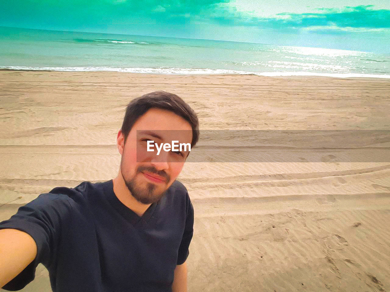 Portrait of young man standing on beach