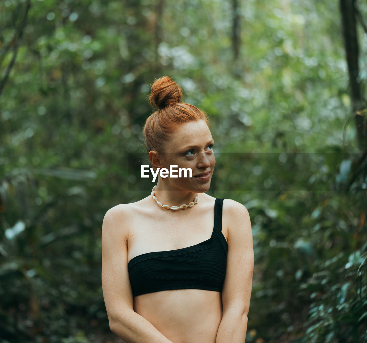 Young woman looking up in forest