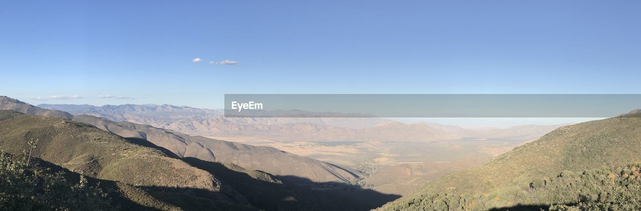 SCENIC VIEW OF LANDSCAPE AND MOUNTAINS AGAINST BLUE SKY