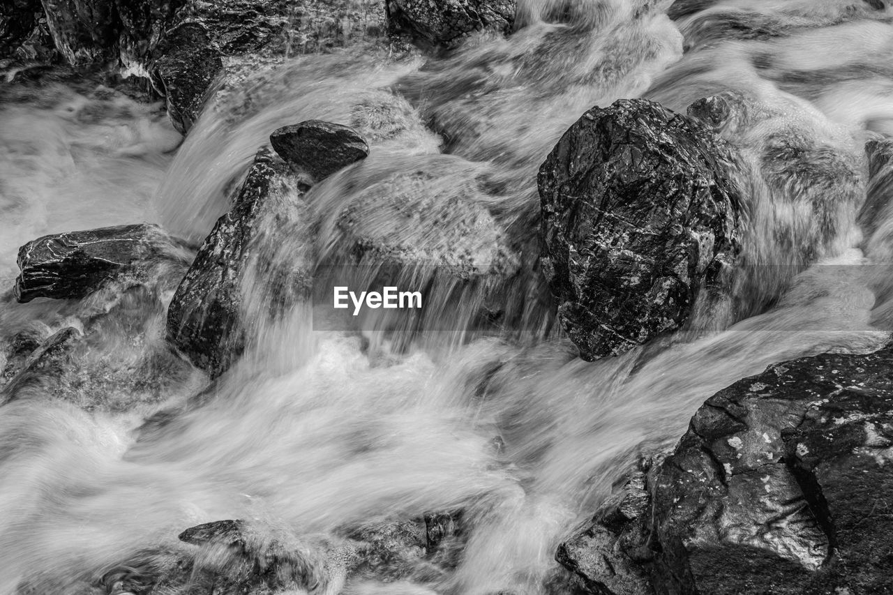 Blurred motion of water over rocks in mountain river