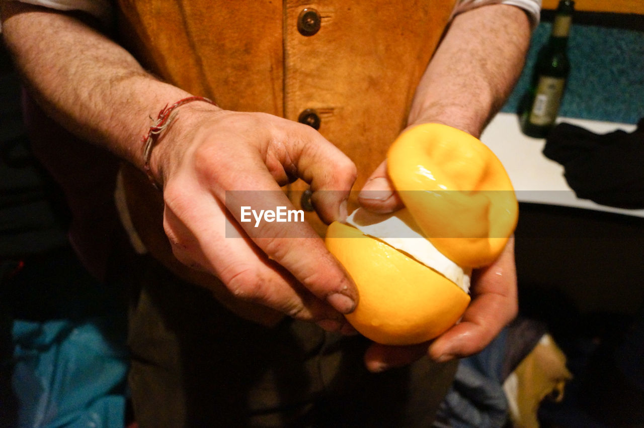 Midsection of man holding fruit