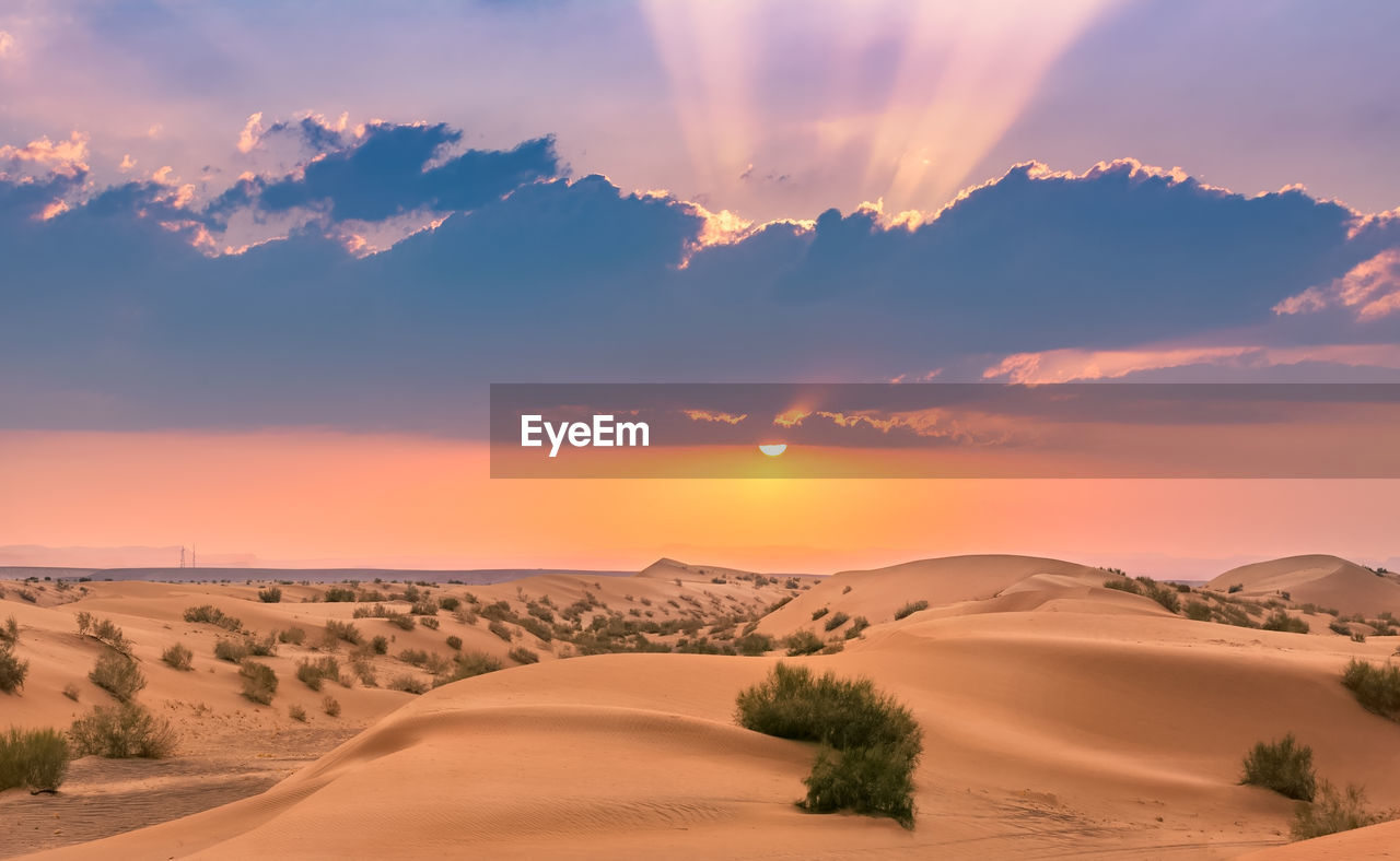 SCENIC VIEW OF DESERT AGAINST SKY AT SUNSET