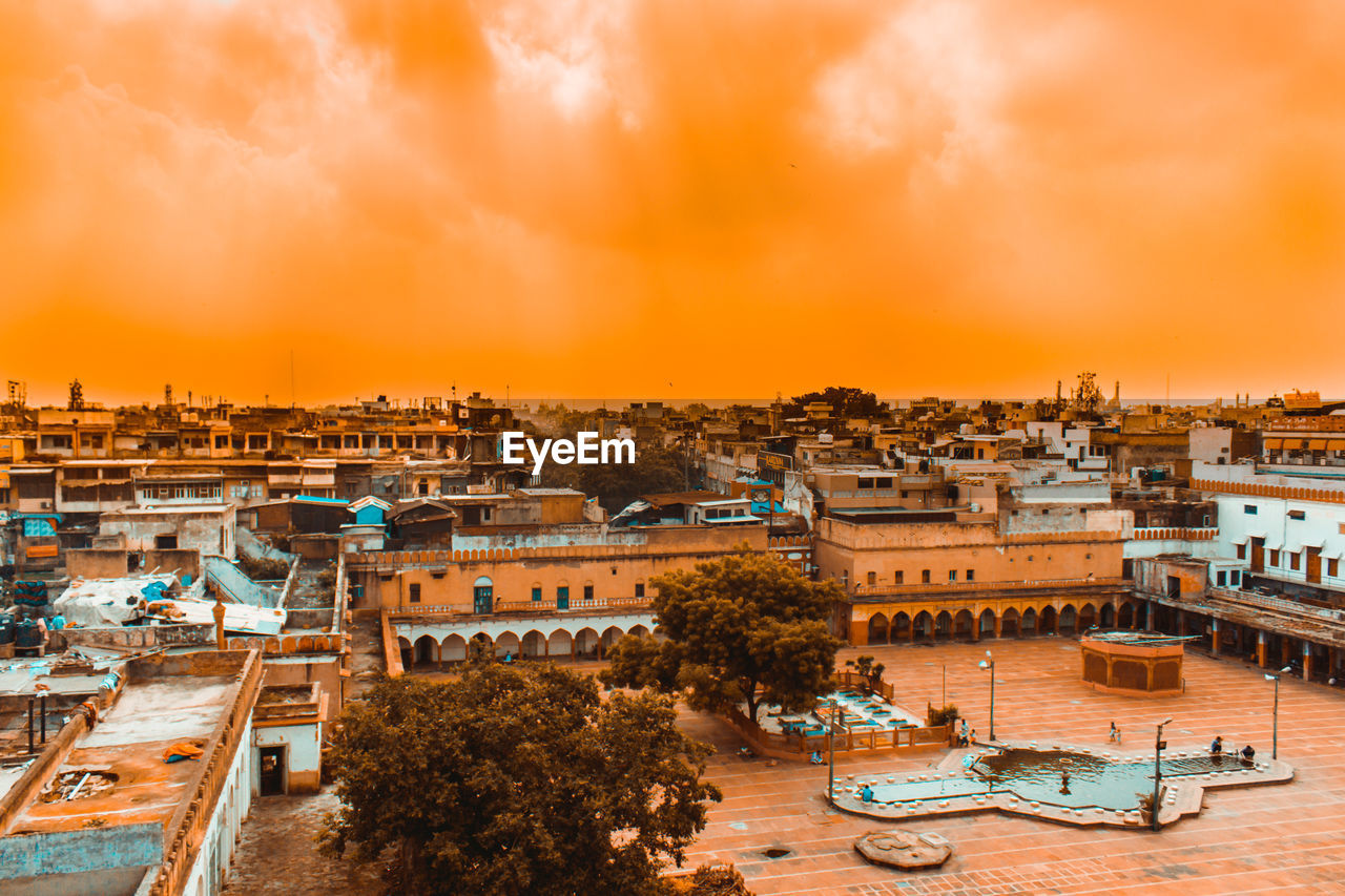 High angle view of buildings and harbor against sky during sunset