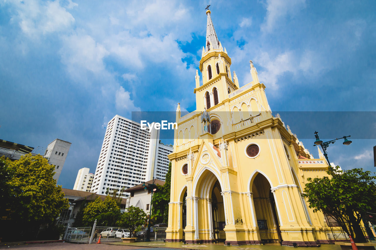 LOW ANGLE VIEW OF BUILDINGS AGAINST CLOUDY SKY