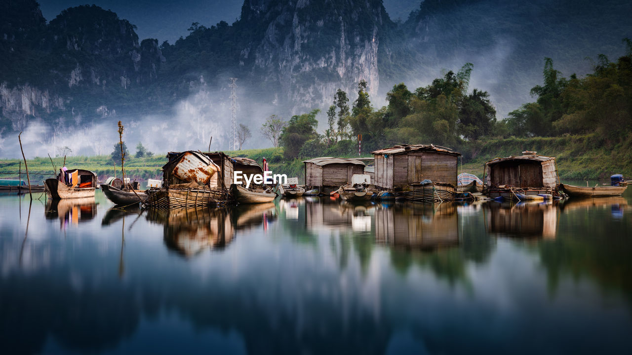 Boathouses on lake by mountains