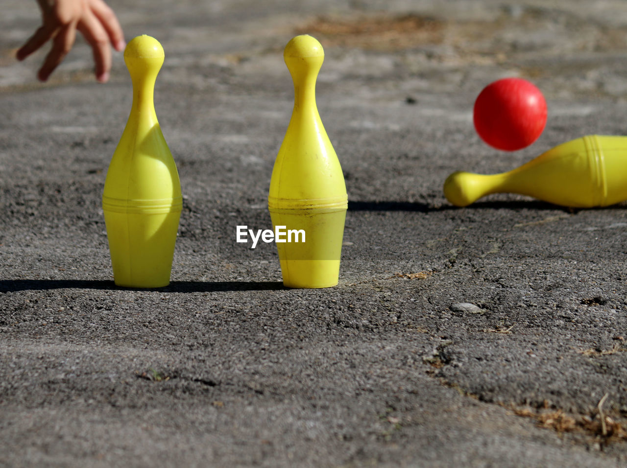 Close-up of yellow bowling pins on road
