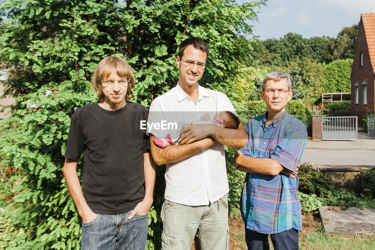 Portrait of family standing against plants