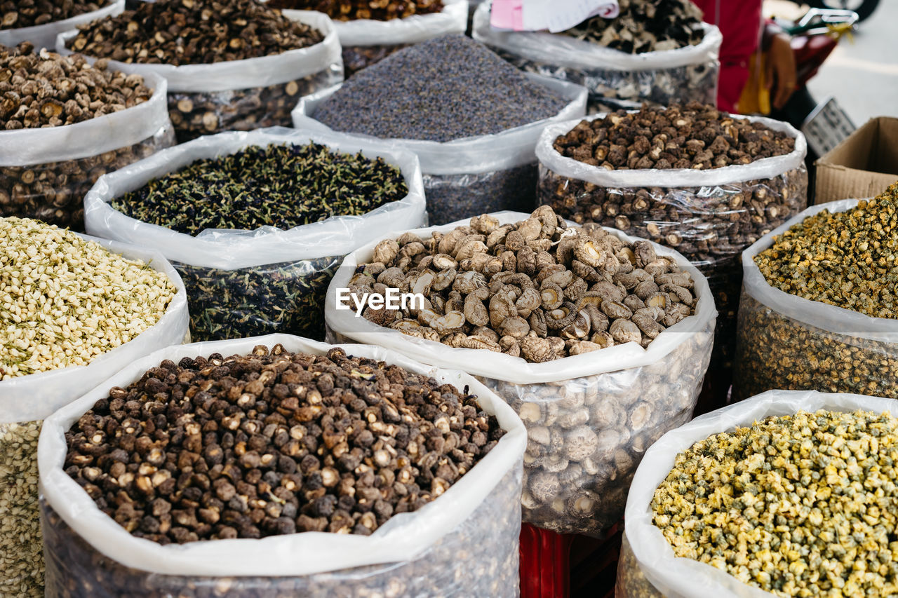 Various spieces and dried vegetables in bags for sale at market stall
