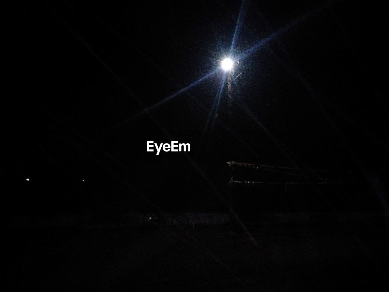 LOW ANGLE VIEW OF ILLUMINATED LAMP AT NIGHT