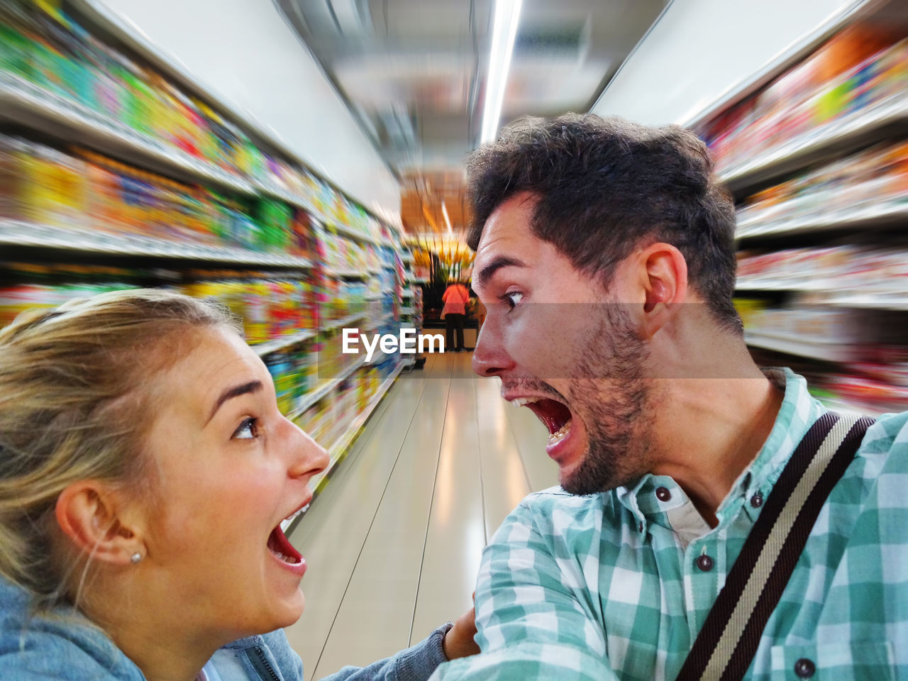 Friends screaming while standing in supermarket