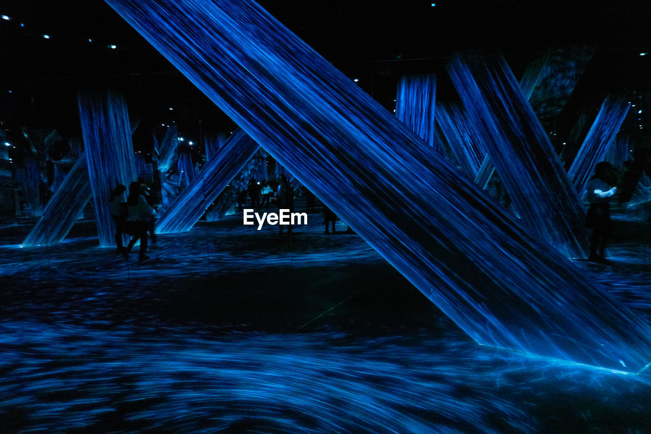 ILLUMINATED BRIDGE OVER SEA AGAINST BLUE SKY