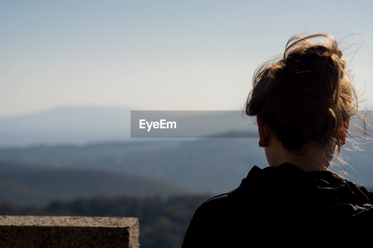 REAR VIEW OF WOMAN LOOKING AT MOUNTAINS