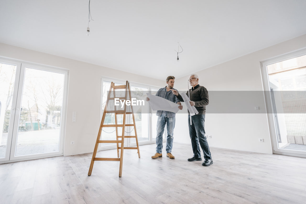 Architect checking construction plan with owner of the new home