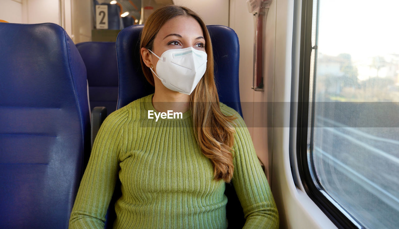 Portrait of woman traveling on public transport wearing protective medical mask. 