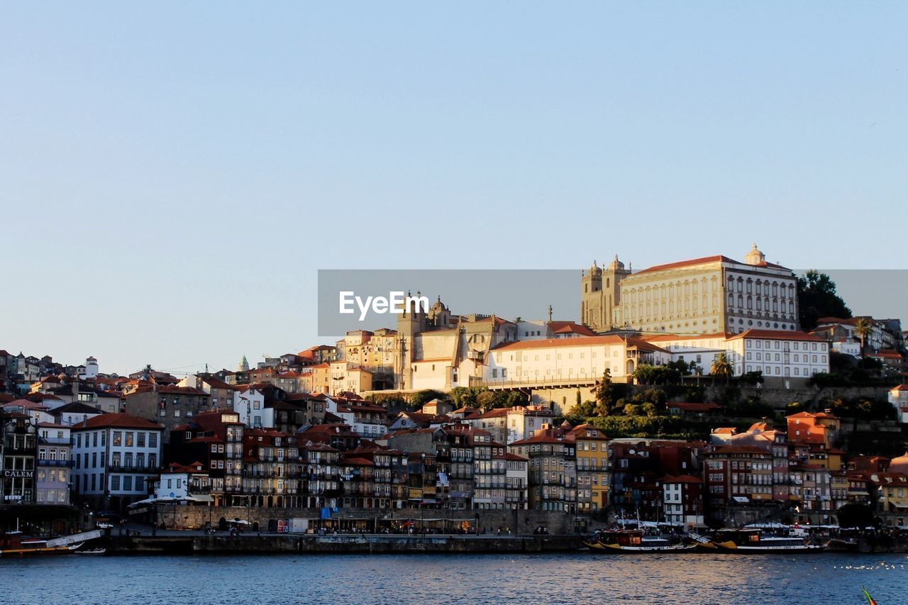 Buildings against clear sky with waterfront