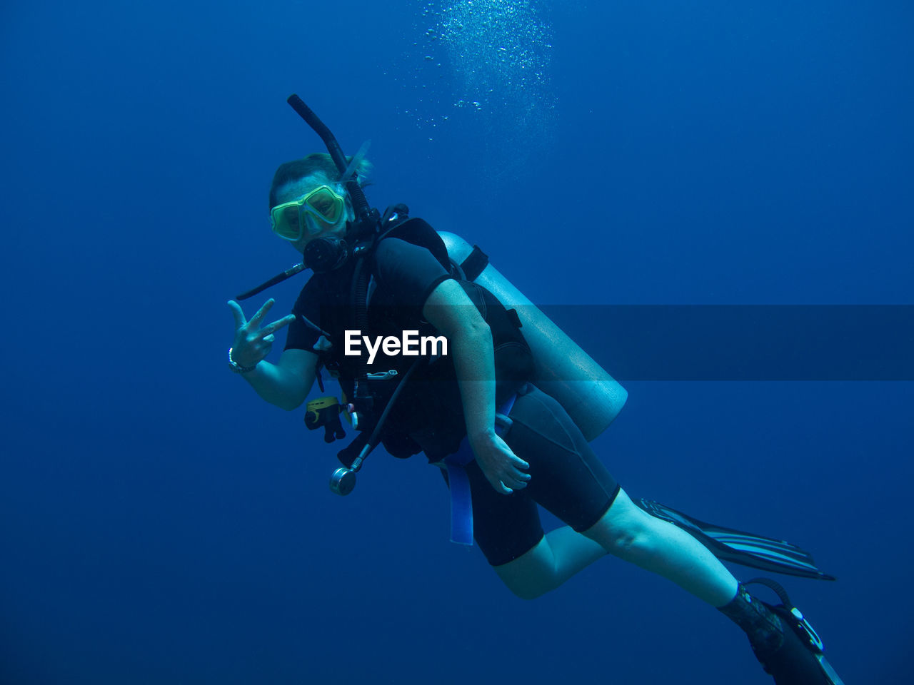 Woman gesturing while scuba diving in sea