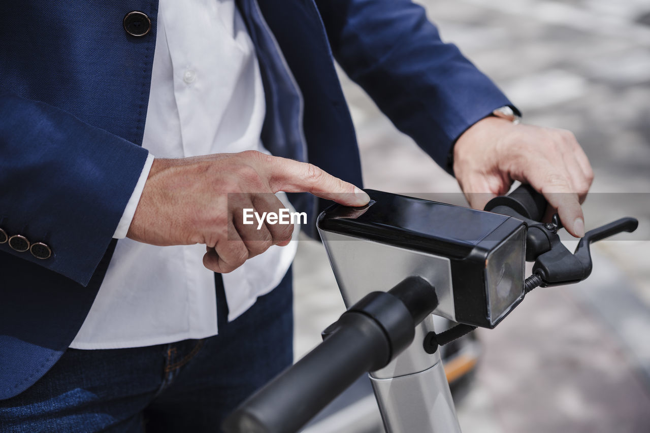 Businessman using electric push scooter