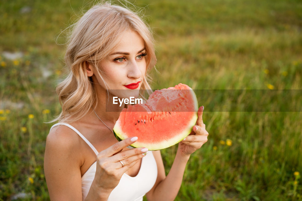 Portrait of woman eating fruit