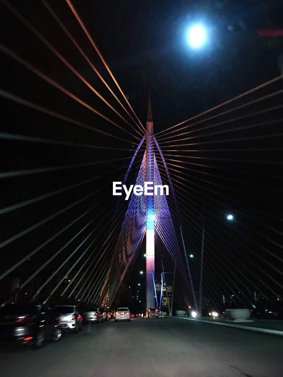 Illuminated bridge against sky at night