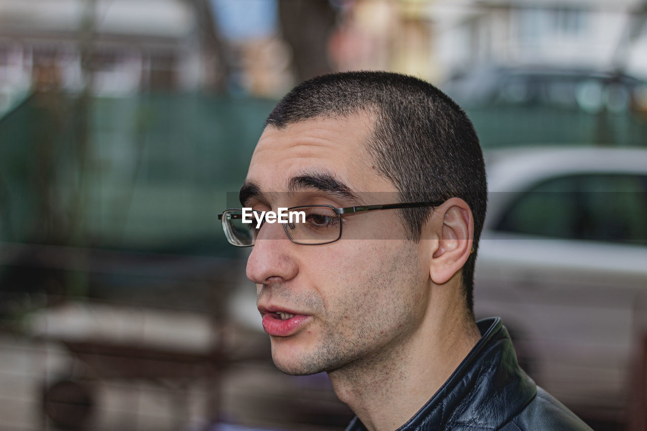 CLOSE-UP PORTRAIT OF YOUNG MAN WITH EYEGLASSES