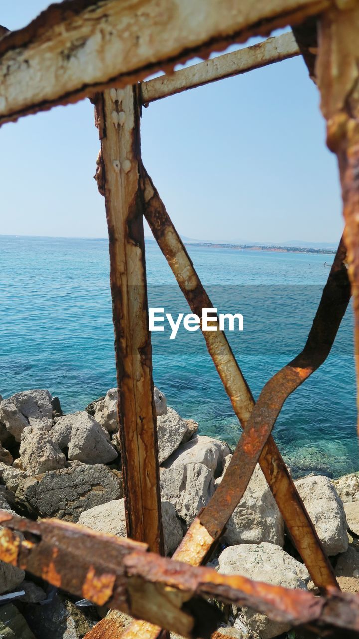 SCENIC VIEW OF SEA AGAINST SKY SEEN THROUGH METAL
