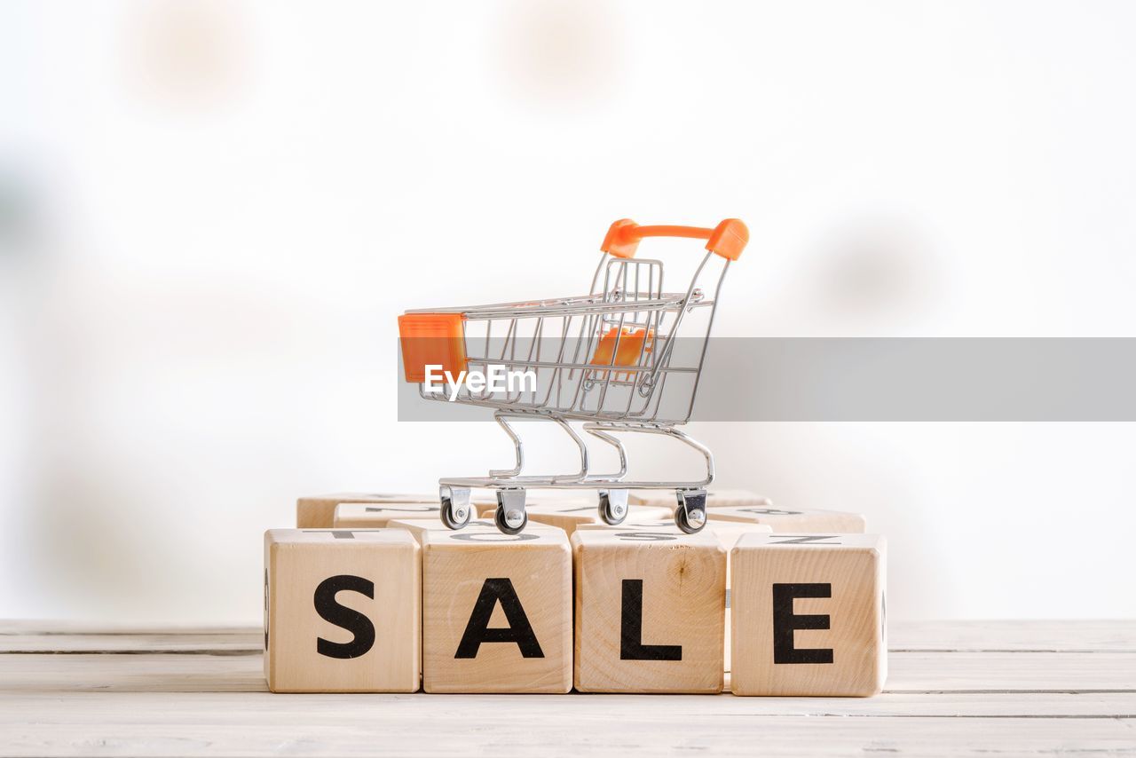 Close-up of small shopping cart on toy blocks