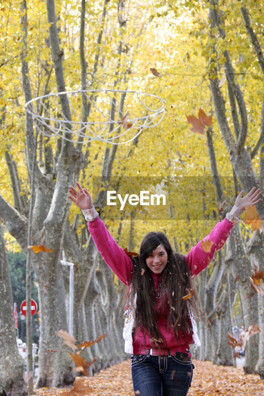 Woman standing against tree in park during autumn